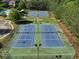 Aerial view of the community tennis courts with lighting and surrounded by green space at 1963 Skybrooke Ln, Hoschton, GA 30548
