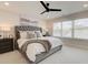 This bedroom features a tufted headboard, a ceiling fan, and a large window for natural light at 4822 Floydwood Ln, Mableton, GA 30126
