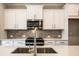 Close-up of the kitchen island with stainless steel sink and appliances, complemented by white cabinetry at 4822 Floydwood Ln, Mableton, GA 30126