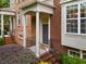 Inviting front porch of a brick townhome with black iron railings, manicured shrubbery, and a welcoming entrance at 4879 Seldon Se Way, Smyrna, GA 30080