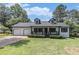 Charming home with a well-manicured lawn, two-car garage, dormer windows and inviting front porch at 5406 Jamestowne Dr, Powder Springs, GA 30127