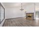 Bright living room boasts wood flooring, a stone fireplace, and a large window at 5406 Jamestowne Dr, Powder Springs, GA 30127