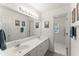 Well-lit bathroom featuring a double sink vanity, framed wall art, and a linen closet at 8032 Ridge Vly, Woodstock, GA 30189
