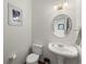 This powder room features tile floors, white walls, pedestal sink, and decorative wall art at 8032 Ridge Vly, Woodstock, GA 30189