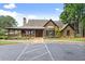 Exterior shot of community clubhouse featuring wood facade, covered porch, and manicured landscaping at 8032 Ridge Vly, Woodstock, GA 30189