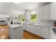 Open kitchen with hardwood floors, white cabinets, island, and view to the dining room and living room at 8032 Ridge Vly, Woodstock, GA 30189