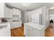 Bright kitchen boasts white cabinets, hardwood floors, an island and stainless appliances at 8032 Ridge Vly, Woodstock, GA 30189