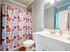 Functional bathroom featuring a single sink vanity, toilet, and a shower with a colorful shower curtain at 1059 Verbena Way, Auburn, GA 30011