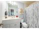 Well-lit bathroom featuring a single vanity, toilet, and a shower with a stylish shower curtain at 1059 Verbena Way, Auburn, GA 30011