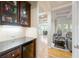 Butler's pantry featuring dark cabinets, granite countertops and decorative glass shelving at 1059 Verbena Way, Auburn, GA 30011