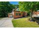 Side view of a beautiful brick home with a three car garage and mature landscaping at 1059 Verbena Way, Auburn, GA 30011