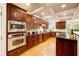 Gourmet kitchen with dark wood cabinetry, stainless appliances, and hardwood floors at 1059 Verbena Way, Auburn, GA 30011