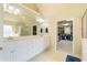 Bright main bathroom with a double sink vanity, large mirror, and access to a walk-in closet at 1059 Verbena Way, Auburn, GA 30011