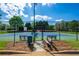Community tennis courts with a blue and green court, a fence, and a bench at 1059 Verbena Way, Auburn, GA 30011