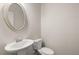 Powder room featuring a pedestal sink, oval mirror, and neutral color palette at 1243 Riverstone Rd, Jonesboro, GA 30238