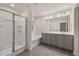 A well-lit bathroom boasts a double vanity, tub, and glass shower, perfect for modern living at 1243 Riverstone Rd, Jonesboro, GA 30238
