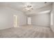 A bright bedroom features neutral carpet, a ceiling fan, and multiple entryways for convenience at 1243 Riverstone Rd, Jonesboro, GA 30238
