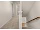 A carpeted hallway with a staircase features a neutral color palette at 1243 Riverstone Rd, Jonesboro, GA 30238