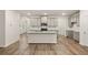Open kitchen with granite counters, stainless appliances, hardwood flooring, gray cabinets, and kitchen island at 1243 Riverstone Rd, Jonesboro, GA 30238