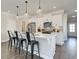 Bright kitchen with pendant lights over the island with white cabinets, stainless appliances, and grey backsplash at 4527 Moray Dr, Mableton, GA 30126