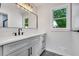 Bathroom featuring modern vanity with marble countertop, dark hardware, and a window for natural light at 615 Nw Mark Trail Nw Ct, Atlanta, GA 30328