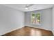 Bright bedroom with hardwood floors, ceiling fan and a window view of a garden at 615 Nw Mark Trail Nw Ct, Atlanta, GA 30328