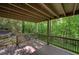 Covered outdoor deck features wooden flooring and metal railings, overlooking lush greenery at 615 Nw Mark Trail Nw Ct, Atlanta, GA 30328