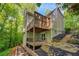 View of a multi-level deck and landscaped yard, surrounded by mature trees at 615 Nw Mark Trail Nw Ct, Atlanta, GA 30328