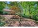 View of home exterior with natural landscaping and mature trees at 615 Nw Mark Trail Nw Ct, Atlanta, GA 30328