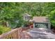 Home exterior featuring a two-car garage with green door, wooden walkway, and surrounded by mature trees at 615 Nw Mark Trail Nw Ct, Atlanta, GA 30328