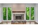 Bright living room with modern fireplace, stone hearth and mantle and large windows with views of nature at 615 Nw Mark Trail Nw Ct, Atlanta, GA 30328
