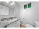 Well-lit bathroom features a modern vanity with granite countertop, toilet, and small window at 2078 Olive Springs Se Rd, Marietta, GA 30060