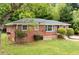 Charming red brick home featuring a well-maintained lawn and mature trees offering shade and curb appeal at 2078 Olive Springs Se Rd, Marietta, GA 30060