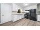 Functional kitchen with ample white cabinetry, black appliances, and modern flooring for cooking and dining at 2078 Olive Springs Se Rd, Marietta, GA 30060