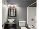Gray bathroom featuring glass bowl sink, shower over tub and a dark framed mirror at 300 Summer Pond Trl, Lawrenceville, GA 30046