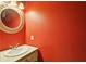 Half bathroom with a wall-mounted sink and a large mirror, painted in bold red color at 300 Summer Pond Trl, Lawrenceville, GA 30046