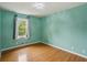 This bedroom features hardwood floors, a window, and light green walls at 300 Summer Pond Trl, Lawrenceville, GA 30046