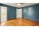 Bedroom with hardwood floors, light-blue walls, and access to a bathroom at 300 Summer Pond Trl, Lawrenceville, GA 30046