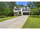 Classic two-story home with a long driveway and an attached two-car garage, surrounded by green lawns at 300 Summer Pond Trl, Lawrenceville, GA 30046