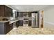 Galley kitchen with stainless steel appliances, granite countertops, and backsplash at 300 Summer Pond Trl, Lawrenceville, GA 30046