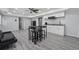Finished basement with gray flooring, kitchenette, table with stools, and a black leather couch at 3123 Morgan Box Ln, Buford, GA 30519