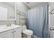 Cozy bathroom featuring a single sink vanity, a toilet, and a shower with a blue curtain at 3123 Morgan Box Ln, Buford, GA 30519
