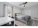 Bright bedroom featuring a striped bed, a ceiling fan, and a table with rolling chairs at 3123 Morgan Box Ln, Buford, GA 30519