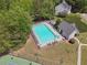 Aerial view of the community pool with lounge chairs and a bath house, as well as a tennis court at 3123 Morgan Box Ln, Buford, GA 30519