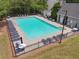Aerial view of a fenced in community pool surrounded by lounge chairs and tables with umbrellas at 3123 Morgan Box Ln, Buford, GA 30519