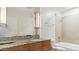 Bathroom featuring a granite countertop, vanity, large mirror, and tiled shower/tub combo at 44 Peachtree Nw Pl # 1728, Atlanta, GA 30309