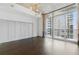 Spacious living room featuring dark hardwood floors and oversized windows with city views at 44 Peachtree Nw Pl # 1728, Atlanta, GA 30309