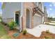 Up close view of new construction townhome with stone and siding details and manicured landscaping at 4523 Moray Dr, Mableton, GA 30126