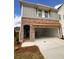 Brick exterior of townhome with large 2-car garage, arched doorway and landscaping at 4523 Moray Dr, Mableton, GA 30126