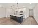Bright kitchen featuring a large island with black base and light countertops, white cabinets and pendant lights at 4523 Moray Dr, Mableton, GA 30126